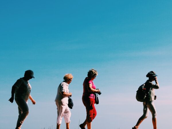 Women walking against a blue sky
